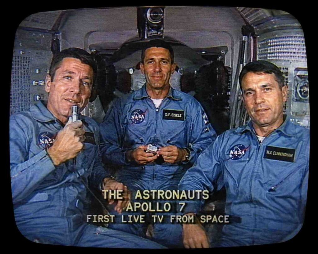 AI-generated vintage TV-style illustration of Apollo 7 astronauts inside the spacecraft during the first live television broadcast from space.